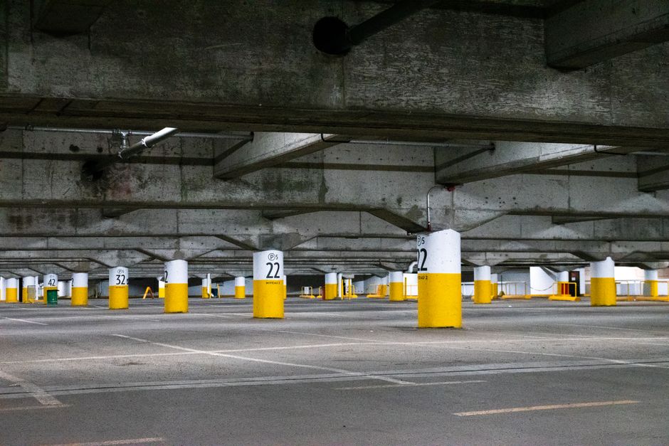 Empty concrete parking structure with numbered columns painted white and yellow.